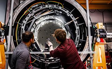 Two scientists in front of MOONS rotating front end.