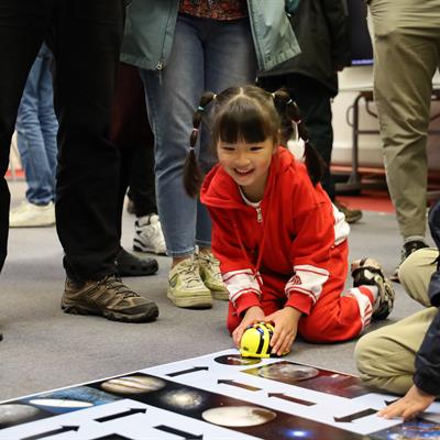 Children playing with small bee-shaped robots.